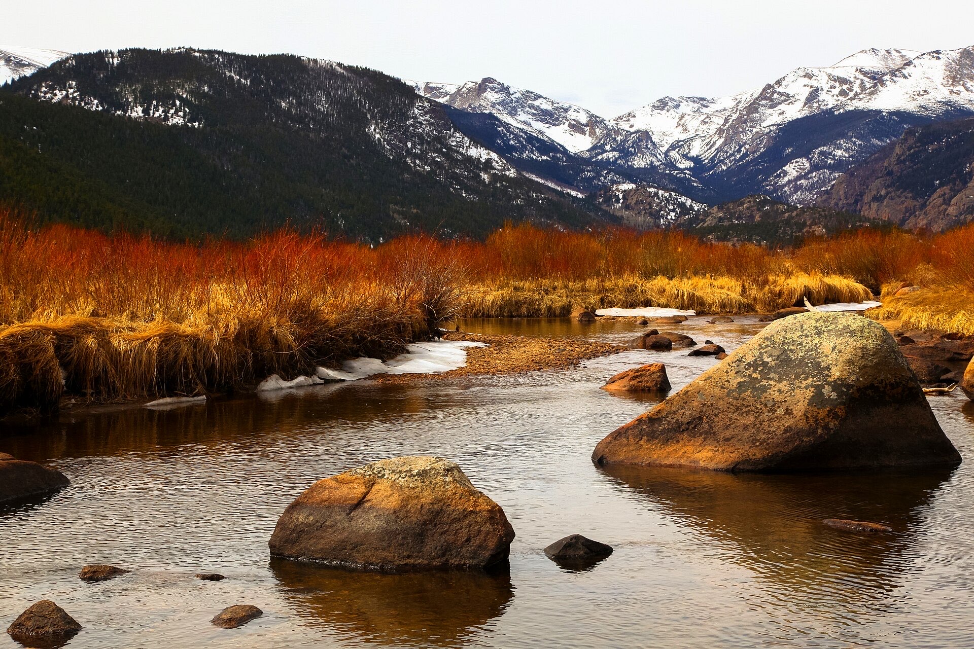 Snowy Rocky Mountain peaks above a winter meadow and creek