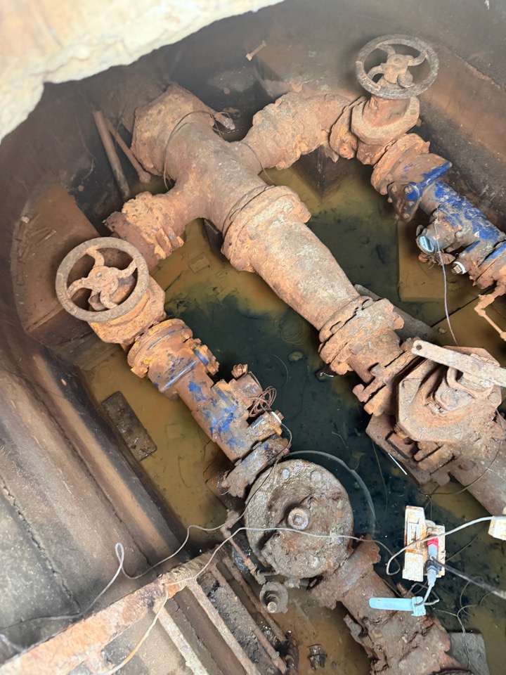 Commercial backflow prevention assemblies in an underground vault, with test tags attached