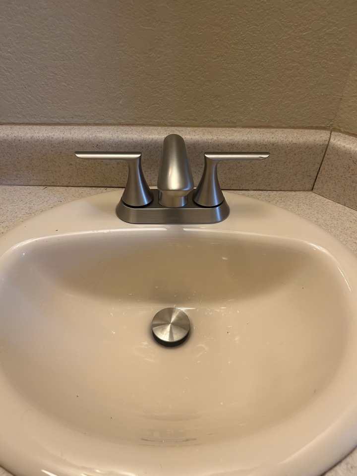 A new brushed-nickel faucet and drain in the same bathroom sink