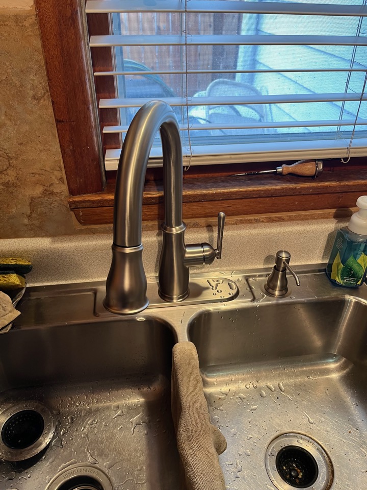 A new pull-down kitchen faucet and soap dispenser at the same stainless sink