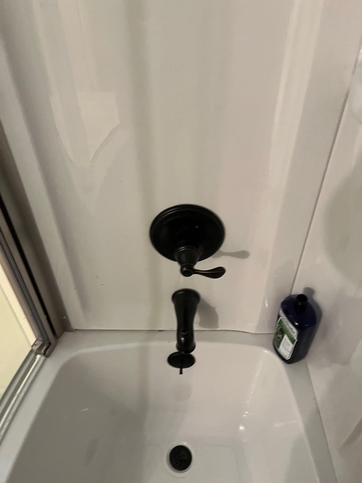 New dark bronze shower valve trim and tub spout on a white tub surround