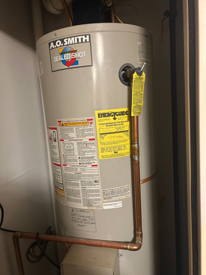 A new A.O. Smith water heater installed in a closet, with copper piping