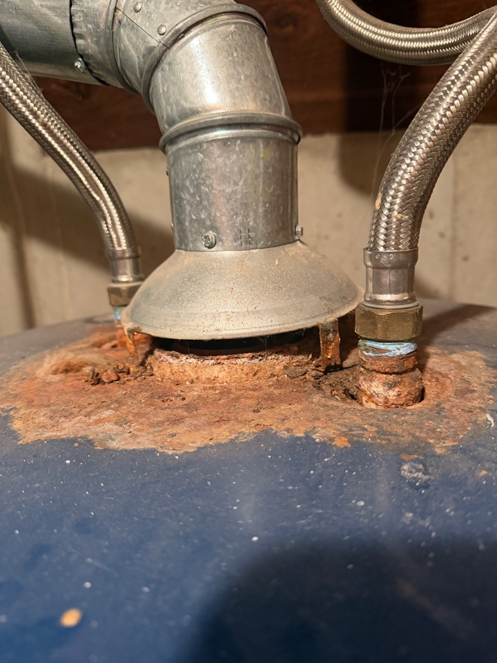 Heavy rust around the vent hood and water connections on top of an old water heater